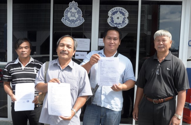 Handing in the police report and the RM3,000 to Miri police station - Headman of Long Mekaba, Lejau Tusau (right) and 3 other villagers.